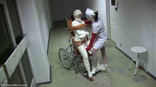 Patient in Wheelchair with Broken Legs and Stra…
